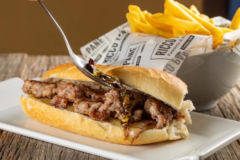 Nova Ricco Pane: Combo Lanche de Inverno Choripan - baguete com linguiça especial, queijo muçarela e finalizado com molho chimichurry - acompanhado de porção de batata frita.