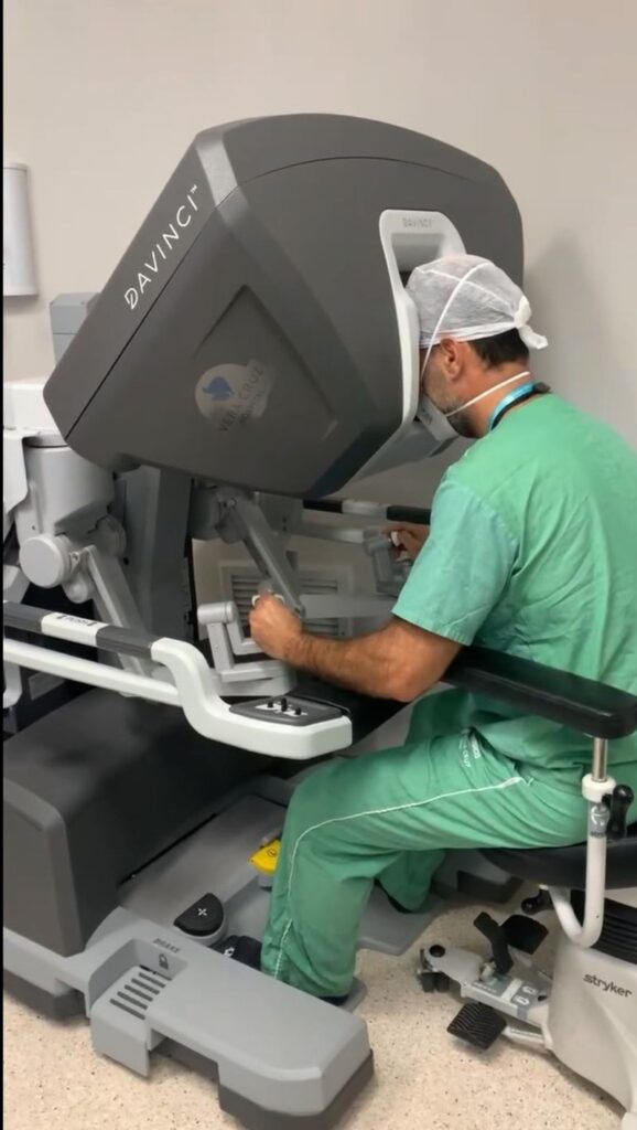 Dr. Rodrigo Garcia conduz cirurgia robótica operando pelo console que controla o robô. Crédito: Divulgação